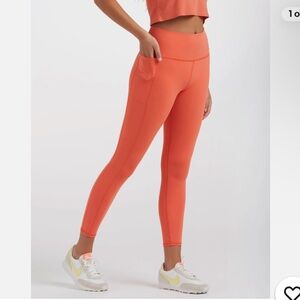 Vuori Studio Pocket Legging in the vibrant "Grapefruit" orange Size medium